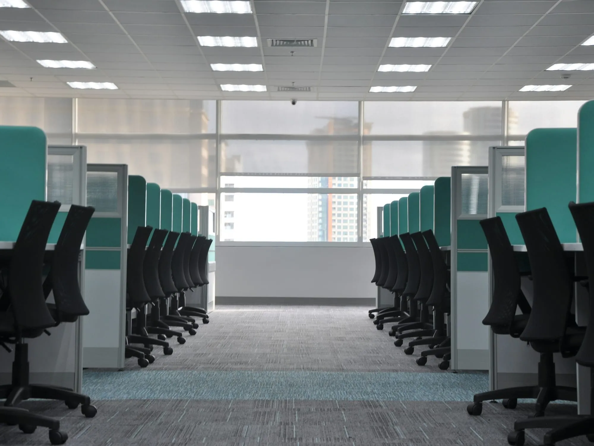 Virtual organization of AI agents - an office with rows of empty desks and chairs